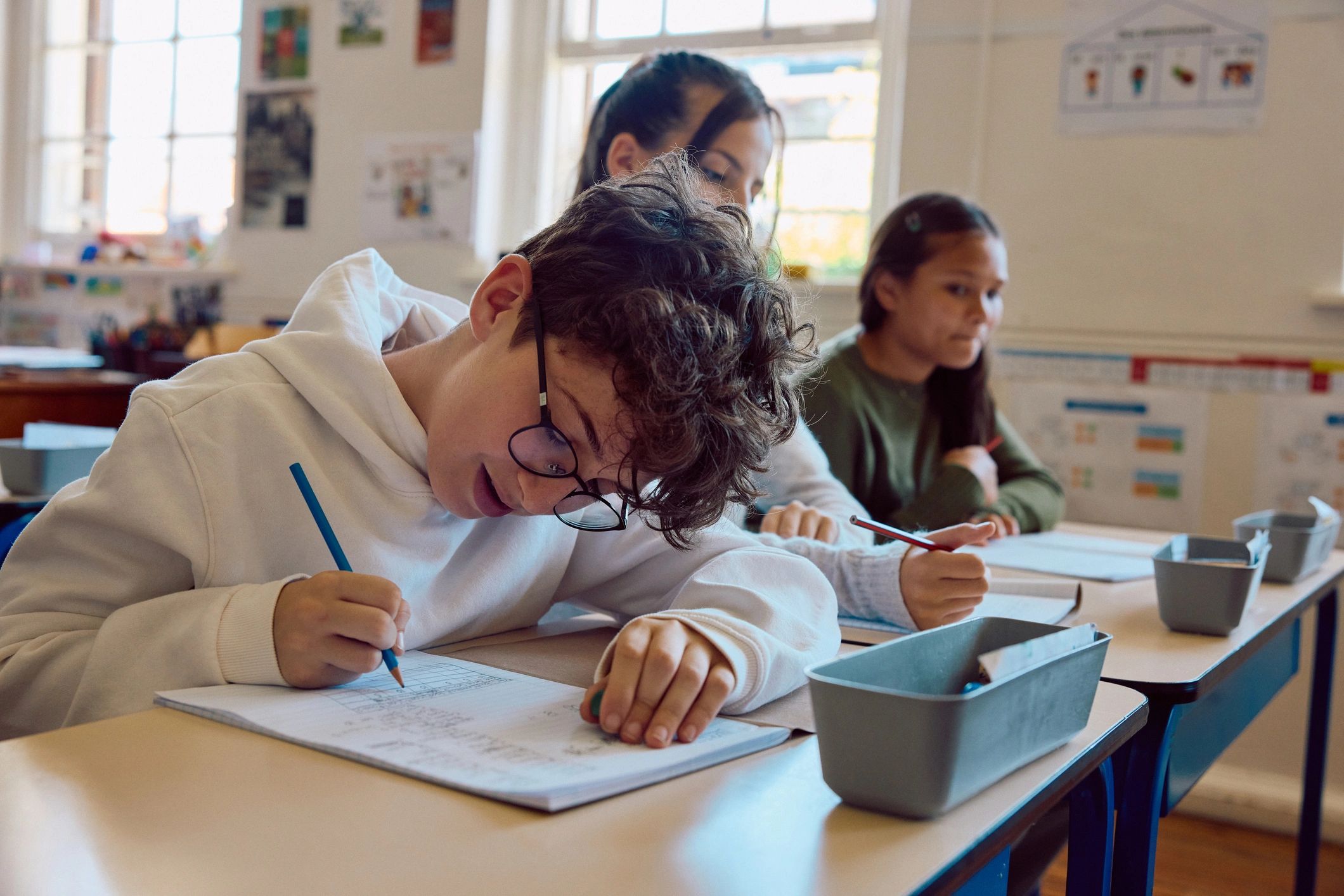 Student writing in a notebook during class